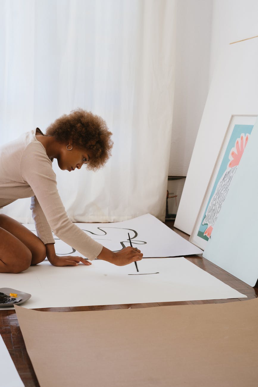 photo of woman painting on white illustration board